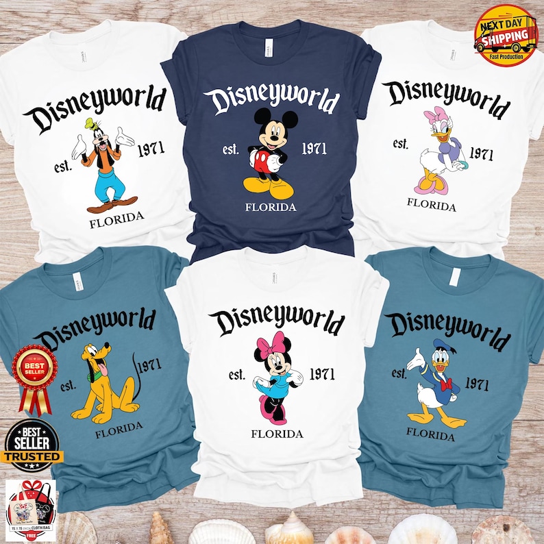 Op de afbeelding: Zes T-shirts met Disney-personages. Elk shirt toont "Disneyworld", het jaar "1971" en "Florida". De shirts zijn wit, marineblauw en blauwgroen, met afbeeldingen van Goofy, Mickey Mouse, Daisy Duck, Pluto, Minnie Mouse en Donald Duck.