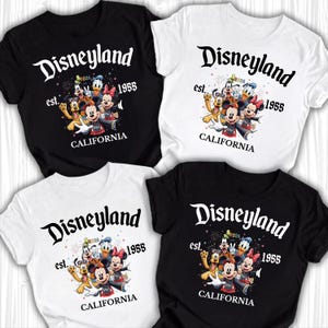May include: Four t-shirts, two black and two white, each featuring a Disneyland graphic. The design includes the word "Disneyland" in a stylized font, the year "1955", and a cartoon character group. The text "CALIFORNIA" is also present.
