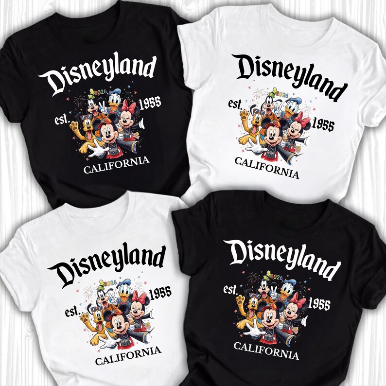 May include: Four t-shirts, two black and two white, each featuring a Disneyland graphic. The design includes the word "Disneyland" in a stylized font, the year "1955", and a cartoon character group. The text "CALIFORNIA" is also present.