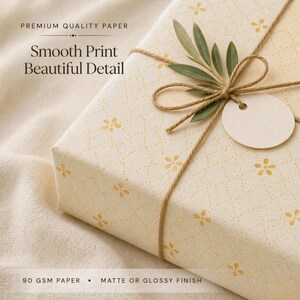 Close-up of floral gift wrap showing smooth print quality, soft golden color, and delicate pattern detail on premium paper