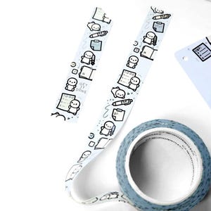 May include: A roll of pale blue washi tape featuring a repeating pattern of cartoon figures, notebooks, pens, and the words "GET IT DONE" in black. Two strips of the same tape are also visible.