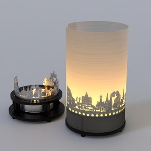 May include: A black metal candle holder with a cityscape silhouette design. The candle holder is lit and the light shines through the cutouts in the metal.