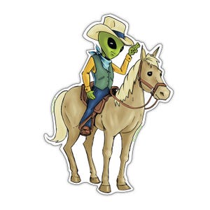 Op de afbeelding: Een sticker met een alien-cowboy op een paard. De alien is groen met zwarte ogen en draagt een cowboyhoed, vest en blauwe jeans. Het paard is bruin met een bruin zadel en hoofdstel. De alien wijst met één hand.