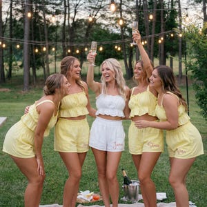 Puede incluir: Una taza de cerámica blanca con un asa negra y el texto "But First, Coffee" en negro, con una fuente de estilo manuscrito. La taza está sobre una superficie blanca.