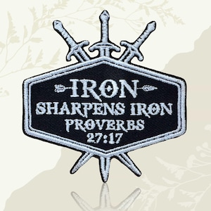 May include: Embroidered black and white patch with three swords above a black hexagon. The patch reads "IRON SHARPENS IRON PROVERBS 27:17" in white. Suitable for clothing or accessories, it has a white border.