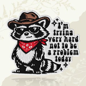 May include: Embroidered patch featuring a raccoon wearing a cowboy hat, sunglasses, and a red bandana. The patch includes the text "I'm trying very hard not to be a problem today" in black lettering.