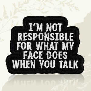 May include: Black embroidered patch with white text: "I'M NOT RESPONSIBLE FOR WHAT MY FACE DOES WHEN YOU TALK." The patch has a black border and a rectangular shape with rounded corners. The text is in a bold, sans-serif font.