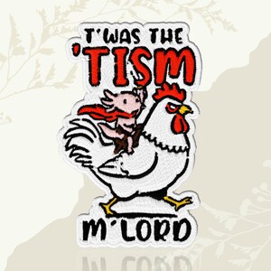 May include: Embroidered patch featuring a white rooster with a red comb and wattle, carrying a pink axolotl wearing a red cape. The patch has the text "T'was the 'TISM m'LORD" in red and black.