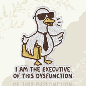 May include: Embroidered patch featuring a cartoon duck wearing sunglasses, a tie, and carrying a briefcase. The patch reads "I AM THE EXECUTIVE OF THIS DYSFUNCTION". The design is in shades of white, brown, and yellow.