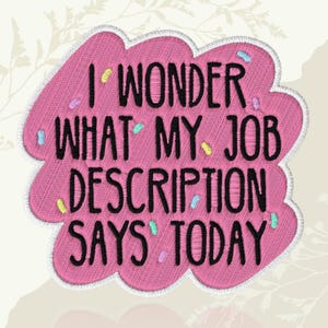 May include: A pink embroidered patch with the text "I WONDER WHAT MY JOB DESCRIPTION SAYS TODAY" in black. The patch has a cloud-like shape with a white border and colorful sprinkles.