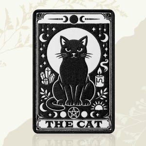 May include: A rectangular embroidered patch featuring a black cat sitting in front of a large white moon. The design includes crystals, a lit candle, stars, crescent moons, a sun, and a pentagram. The text THE CAT is printed at the bottom.