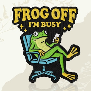 May include: Embroidered patch featuring a green frog in a blue office chair, holding a phone. The patch has the text "FROG OFF I'M BUSY" in yellow, with black and blue accents. The frog is relaxed, with yellow feet.