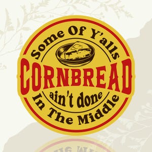 May include: A circular yellow and red graphic with the words "Some Of Y'alls CORNBREAD ain't done In The Middle." A drawing of cornbread with butter is in the center. The background is a light beige with leaf designs.