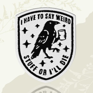 May include: Embroidered patch with a black raven holding a mug, surrounded by stars. Text reads "I HAVE TO SAY WEIRD STUFF OR I'LL DIE" in a shield shape. White and black design.