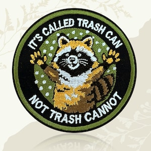 May include: Embroidered patch featuring a raccoon with outstretched arms. The patch is circular with a black border and green background. Text reads "IT'S CALLED TRASH CAN NOT TRASH CANNOT". The raccoon has brown, white, and yellow fur.
