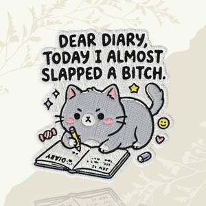 May include: An embroidered patch featuring a gray cartoon cat writing in a diary with a pencil. The text reads, "DEAR DIARY, TODAY I ALMOST SLAPPED A BITCH." The design includes small pink cheeks, a yellow star, a pink heart, a candy, and a smiley face.