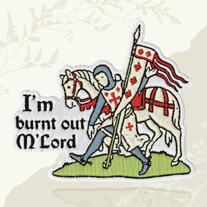 May include: Embroidered patch featuring a medieval knight on horseback, holding a banner. The knight is dressed in blue and red armor. The patch includes the text "I'm burnt out M'Lord" in a stylized font, with a green border.