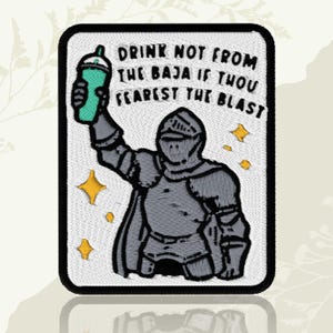 May include: Embroidered patch featuring a knight holding a green beverage cup. The knight is clad in gray armor, with the text "DRINK NOT FROM THE BAJA IF THOU FEAREST THE BLAST" above. Includes yellow star accents.