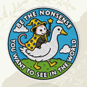 May include: A circular embroidered patch featuring a white goose carrying an opossum dressed in a yellow wizard hat and cape with blue stars. The opossum holds a star-tipped wand. The text BE THE NONSENSE YOU WANT TO SEE IN THE WORLD surrounds them.