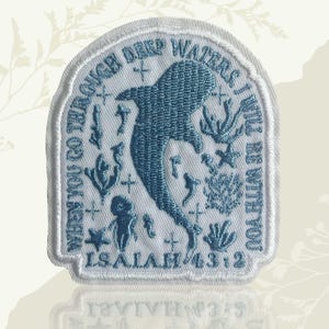May include: Embroidered patch with a light blue whale design and aquatic elements on a white background. The patch features the text "WHEN YOU GO THROUGH DEEP WATERS, I WILL BE WITH YOU" and "ISAIAH 43:2" in a matching blue.