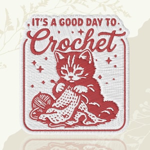 May include: Embroidered patch with a red cat crocheting, a ball of yarn, and the text "IT'S A GOOD DAY TO Crochet". The patch has a white background and a red border. Ideal for craft enthusiasts.