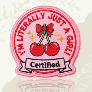 May include: A white ceramic mug with a black handle and the text "But First, Coffee" in a bold, black font. The mug is set against a blurred background, suggesting a cosy setting.