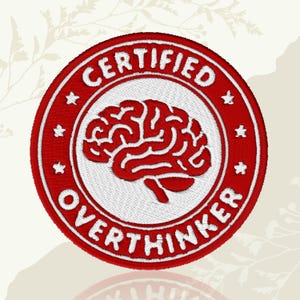 May include: Embroidered patch with a red and white design. The patch features a red brain graphic in the center, surrounded by the words "CERTIFIED OVERTHINKER" in white, within a red circle. Small white stars are placed around the circle.