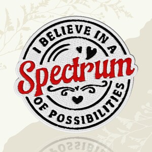 May include: Embroidered patch with the text "I BELIEVE IN A Spectrum OF POSSIBILITIES" in a circular design. The word "Spectrum" is in red, with black and white accents. The patch has a white background and a black border.