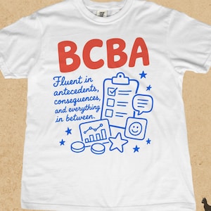 Könnte beinhalten: Ein weißes T-Shirt mit kurzen Ärmeln, das den roten Schriftzug BCBA und blaue grafische Illustrationen zeigt, darunter ein Klemmbrett mit Checkliste, eine Sprechblase, ein Balkendiagramm, ein Smiley-Symbol und Sterne mit dem Text Fluent in antecedents, consequences, and everything in between.