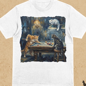 Puede incluir: Camiseta blanca con una ilustración detallada de gatos jugando al billar en una habitación con poca luz. La obra de arte incluye un gato atigrado naranja tirando, un gato gris en un taburete y un gato blanco arriba. La palabra "WHITE" está impresa en la parte superior.