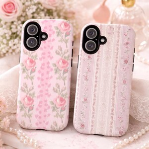 May include: Two rectangular mobile phone cases featuring floral patterns. The left case displays pink roses on a light pink background. The right case features vertical stripes with small pink floral motifs on a pale pink and white background.