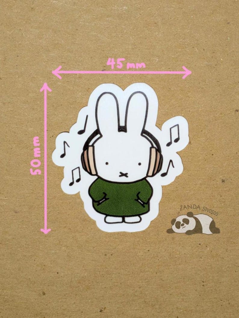 May include: A white bunny sticker wearing headphones and a green dress, with musical notes around it. The sticker is 50mm tall and 45mm wide. A small panda illustration and the text "Zanda Studios" are also present.