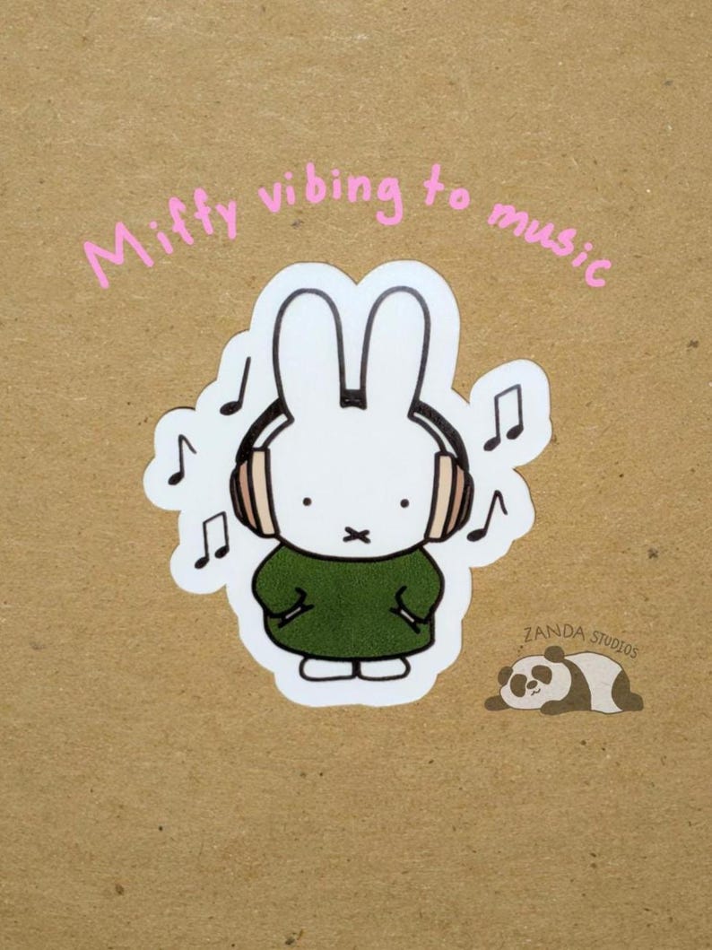 May include: A white bunny sticker with headphones, wearing a green dress, and musical notes. The text "Miffy vibing to music" is written above the bunny. A panda sticker is in the bottom right corner. The sticker is on a brown background.