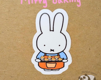 May include: A white bunny sticker with the text "Miffy baking" in pink. The bunny wears a blue shirt and orange apron, holding a tray of muffins. A small panda illustration is in the bottom right corner.