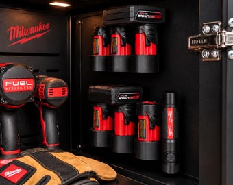 Può includere: L'interno di un armadietto nero con utensili elettrici a marchio Milwaukee, tra cui due trapani a batteria con corpo rosso e nero, diverse batterie rosse M12 Redlithium montate a parete e una torcia nera con dettagli rossi.