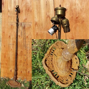 May include: An antique floor lamp with a twisted metal pole and ornate base. The lamp has three light sockets with brass-colored fixtures. The base is a decorative, cast-iron design. The lamp is a dark, rusty brown color.