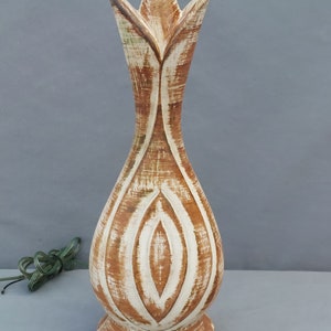 May include: A ceramic table lamp with a white and brown striped design. The lamp has a wide base and a narrow neck with a flower-like opening at the top.