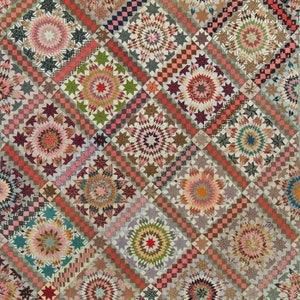 Puede incluir: Una colcha vintage con un patrón repetitivo de diseños de estrella en forma de estallido en tonos de rosa, rojo, marrón, verde y azul. La colcha está hecha de cuadrados con un patrón a cuadros en las esquinas.