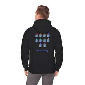 Op de afbeelding: Zwarte hoodie met een kleurrijke afbeelding van ijsjes en de tekst "Choose Wisely" in het blauw. De ijsjes hebben verschillende gekleurde toppings. De hoodie is gemaakt van een zacht materiaal.