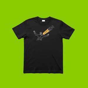 May include: Black t-shirt featuring a white outline illustration of a person with arms raised, and a syringe with the word "HOPE" in yellow. The syringe is angled towards the person. The t-shirt is displayed on a green background.