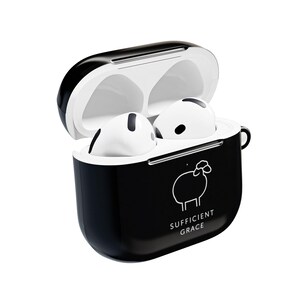 May include: Black and white AirPods case with a sheep graphic and the words "SUFFICIENT GRACE." The case is open, revealing two white AirPods. The case has a glossy finish and a small loop on the side.