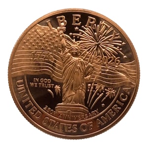 May include: A copper-colored commemorative coin featuring the Statue of Liberty, a waving American flag, and fireworks. Text includes LIBERTY, 1776, 2026, IN GOD WE TRUST, 250TH ANNIVERSARY, and UNITED STATES OF AMERICA embossed on the circular surface.