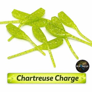May include: Chartreuse Charge fishing lures. These soft plastic lures are chartreuse green with black flecks. The lures have a paddle tail design and are arranged on a white background. The text "Chartreuse Charge" is displayed in a green and yellow rectangle.