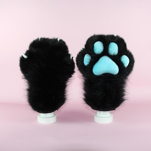 May include: A white ceramic mug with a black handle and the text "But First, Coffee" in a handwritten style. The mug is on a white surface. The mug is 4 inches tall.