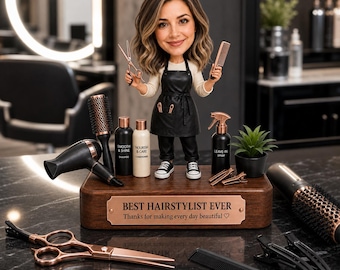 May include: A bobblehead figure of a hairstylist wearing a black apron, holding scissors and a comb, standing on a wooden base with a plaque reading BEST HAIRSTYLIST EVER. The base holds miniature hair products, a dryer, and brushes.