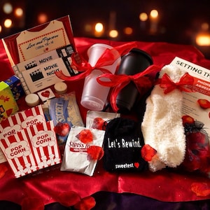 May include: A romantic gift basket with popcorn, candy, movie tickets, and drinks, tied with red ribbons. Includes a plush white item, a black bag with text, and a document with the words "Setting the Mood".