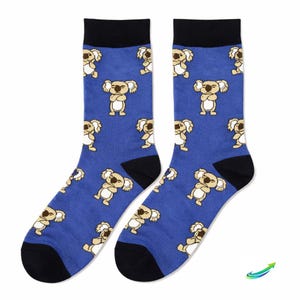 May include: A pair of blue socks featuring a repeating pattern of cartoon koalas. The socks have black heels, toes, and top bands. The koalas are beige and white.