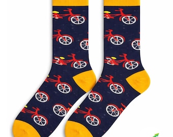 May include: A pair of navy blue socks with a repeating pattern of red bicycles with white wheels. The socks have yellow heels and cuffs. The socks are designed for adults.