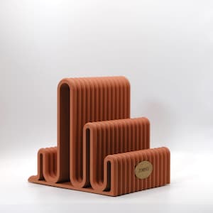 May include: A trio of ceramic mugs with a speckled, matte finish in cream, light grey, and dark grey. Each mug has a simple, modern design and a rounded handle. Ideal for tea or coffee.