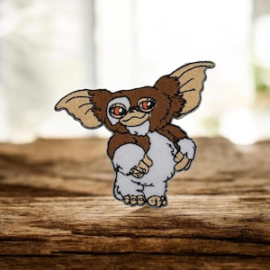 May include: A white ceramic mug with a black handle and the text "But First, Coffee" in a black, handwritten-style font. The mug is on a white surface.